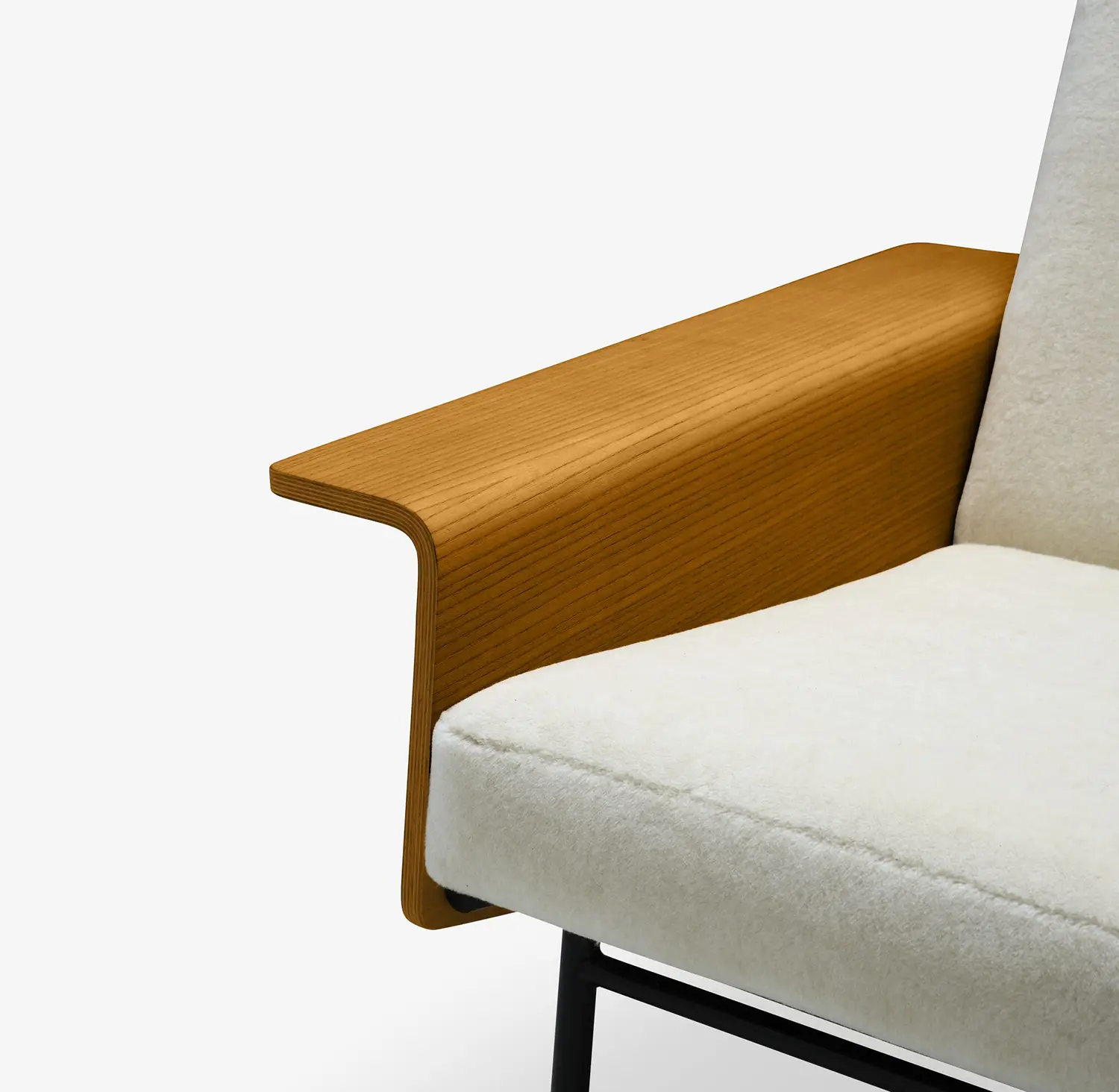 Close-up of a modern armchair with a curved wooden armrest and cream upholstered cushion.